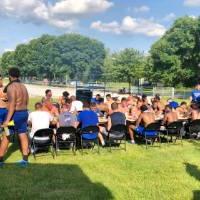Football team eating at large table outdoors